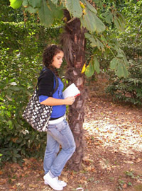 Una alumna lee una leyenda a la sombra de un árbol