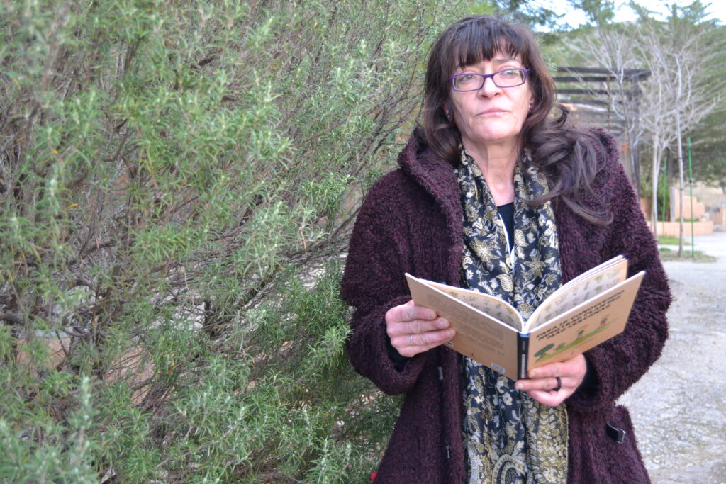 Julia Martínez con un ejemplar de su libro junto a una planta de tomillo/ ANTONIO ARENAS